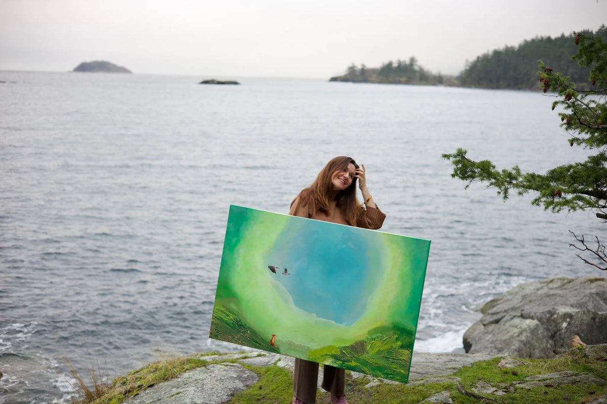 Artist holding a painting in the landscape